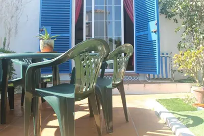 two green chairs sitting at a table on a patio at Apartamento La Barca in Chiclana de la Frontera
