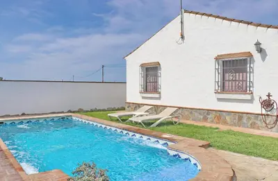 a house with a swimming pool next to a building at Chalet de la casa Forestal in Conil de la Frontera