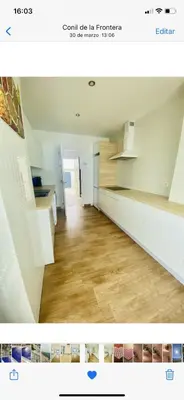 a kitchen with white cabinets and a wooden floor at Spacious villa in Conil de la Frontera with private pool in Conil de la Frontera