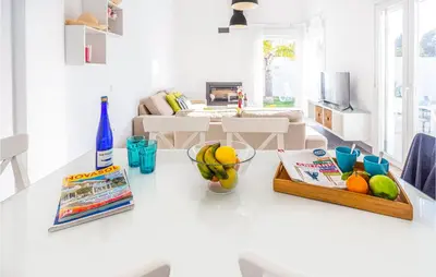 a kitchen with a table with a bowl of fruit on it at Nice Home In Conil De La Frontera in Conil de la Frontera