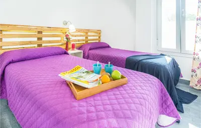 a purple bed with a tray of fruit on it at Nice Home In Conil De La Frontera in Conil de la Frontera