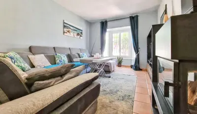 a living room with a couch and a tv at Sunny villa with private pool in Chiclana de la Frontera in Chiclana de la Frontera