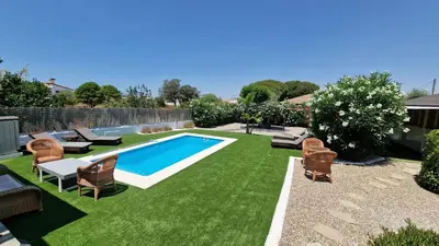 a backyard with a swimming pool and green grass at Sunny villa with private pool in Chiclana de la Frontera in Chiclana de la Frontera