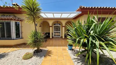 a house with palm trees in front of it at Sunny villa with private pool in Chiclana de la Frontera in Chiclana de la Frontera
