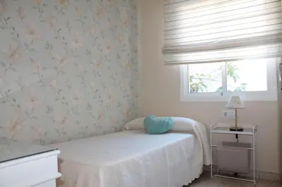 a bedroom with a white bed and a window at APARTAMENTO SAN NICOLAS in Sanlúcar de Barrameda