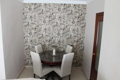 a dining room with a table and white chairs at APARTAMENTO SAN NICOLAS in Sanlúcar de Barrameda