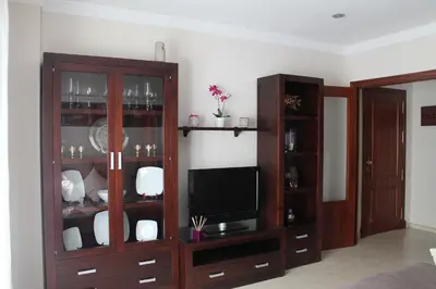 a living room with a entertainment center with a television at APARTAMENTO SAN NICOLAS in Sanlúcar de Barrameda