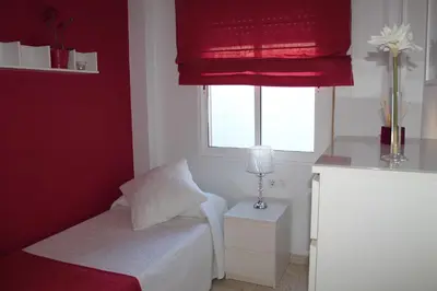 a small bedroom with a bed and a window at APARTAMENTO SAN NICOLAS in Sanlúcar de Barrameda