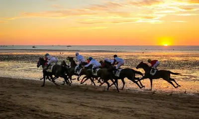 a group of people riding horses on the beach at APARTAMENTO SAN NICOLAS in Sanlúcar de Barrameda