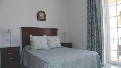 a bedroom with a bed and a window at Apartamento en el centro in Sanlúcar de Barrameda