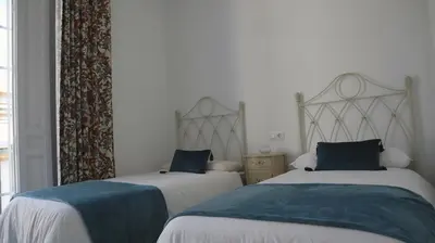a bedroom with two beds with blue pillows at Apartamento en el centro in Sanlúcar de Barrameda