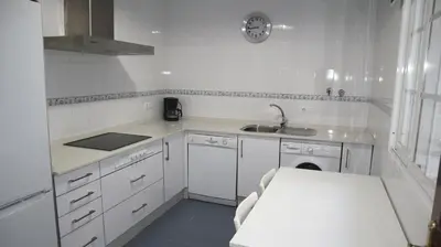 a kitchen with white cabinets and a sink and a stove at Apartamento en el centro in Sanlúcar de Barrameda