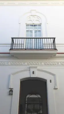 a building with a balcony and a door with a gate at Apartamento en el centro in Sanlúcar de Barrameda