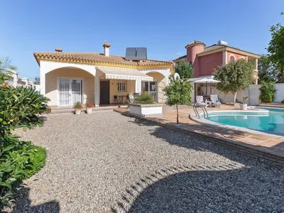a home with a swimming pool and a house at Costa de la Luz Poolside Villa in Sanlúcar de Barrameda