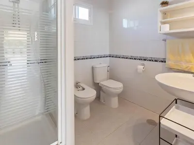 a white bathroom with a toilet and a sink at Costa de la Luz Poolside Villa in Sanlúcar de Barrameda