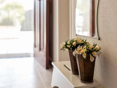 two vases with flowers on a table in a room at Costa de la Luz Poolside Villa in Sanlúcar de Barrameda
