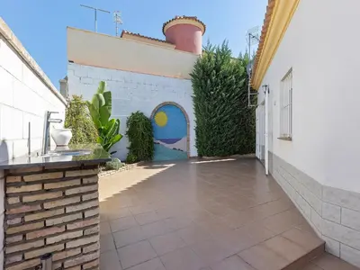 a courtyard of a house with a brick wall at Costa de la Luz Poolside Villa in Sanlúcar de Barrameda