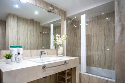 a bathroom with a sink and a shower with a mirror at Santo Tomás B Ha Apartment in Cádiz