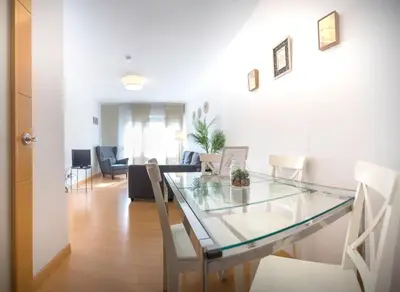 a dining room and living room with a glass table at Santo Tomás B Ha Apartment in Cádiz