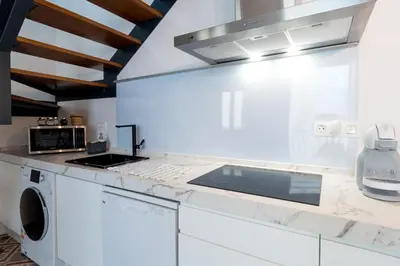 a white kitchen with a sink and a stove at Atico Gades de la Catedral in Cádiz