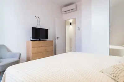 a bedroom with a bed and a tv on a dresser at Atico Gades de la Catedral in Cádiz