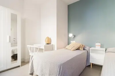 a bedroom with a bed and a blue wall at Atico Gades de la Catedral in Cádiz