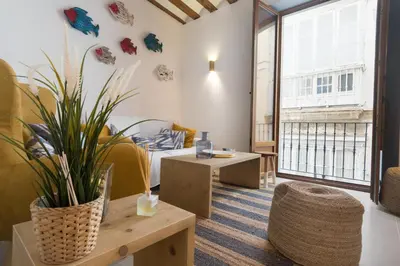 a room with tables and chairs and a large window at Atico Gades de la Catedral in Cádiz