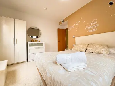 a bedroom with a large bed and a kitchen at URBAN BEACH Grupo AC Gestion in Cádiz