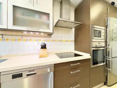 a kitchen with stainless steel appliances and brown cabinets at URBAN BEACH Grupo AC Gestion in Cádiz