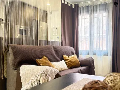 a living room with a couch and a window at URBAN BEACH Grupo AC Gestion in Cádiz