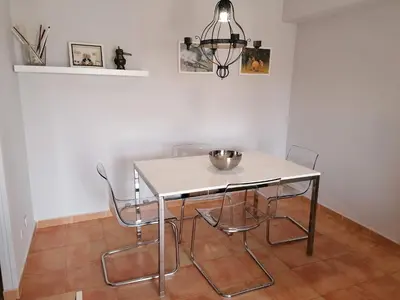 a dining room table with chairs and a bowl on it at Apto Playa de Regla, primera linea, Parking, AA y wifi in Chipiona