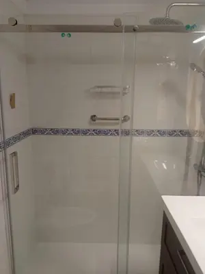 a shower with a glass door in a bathroom at Apto Playa de Regla, primera linea, Parking, AA y wifi in Chipiona