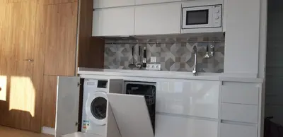 a kitchen with a washing machine and a microwave at PRIMERA LINEA DE PLAYA EN VALDELAGRANA in El Puerto de Santa María