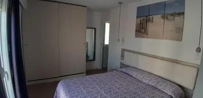 a bedroom with a bed and a large closet at PRIMERA LINEA DE PLAYA EN VALDELAGRANA in El Puerto de Santa María