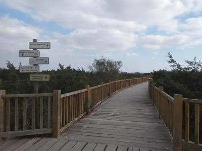 a wooden bridge with many signs on it at PRIMERA LINEA DE PLAYA EN VALDELAGRANA in El Puerto de Santa María