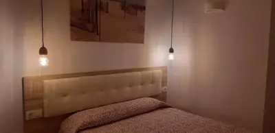 a bedroom with a bed with two lights above it at PRIMERA LINEA DE PLAYA EN VALDELAGRANA in El Puerto de Santa María