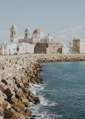 a group of buildings on a rocky beach with the water at No 38 Cádiz in Cádiz