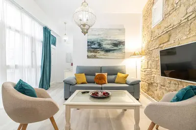 a living room with a couch and a tv at Allo Apartments Amargura I Centro Loft in Jerez de la Frontera