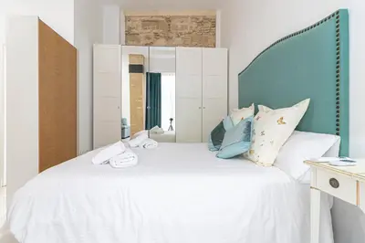 a bedroom with a white bed with a blue headboard at Allo Apartments Amargura I Centro Loft in Jerez de la Frontera