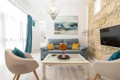 a living room with a blue couch and two chairs at Allo Apartments Amargura I Centro Loft in Jerez de la Frontera