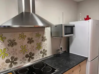 a kitchen with a stove and a microwave and a refrigerator at La Gaviota & Parking privado Grupo AC Gestion in Cádiz