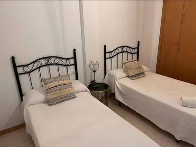 two beds in a bedroom with a lamp on a table at La Gaviota & Parking privado Grupo AC Gestion in Cádiz