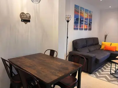 a living room with a table and a couch at La Gaviota & Parking privado Grupo AC Gestion in Cádiz