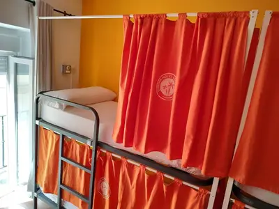 a bunk bed with a red curtain in a room at Summer Cádiz in Cádiz