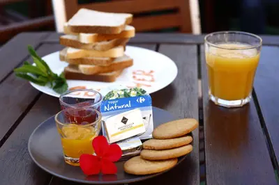 a table with a plate of bread and a glass of orange juice at Summer Cádiz in Cádiz