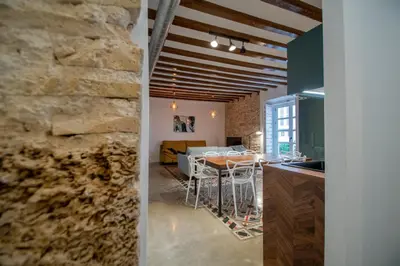 a kitchen and dining room with a stone wall at Apartamentos Son de Cadiz in Cádiz