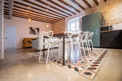 a dining room with white chairs and a table at Apartamentos Son de Cadiz in Cádiz