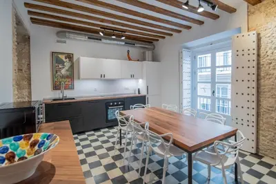 a kitchen with a wooden table and chairs at Apartamentos Son de Cadiz in Cádiz