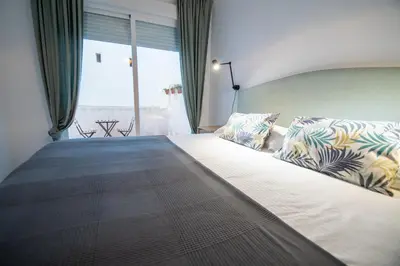 a bedroom with a large bed with a large window at Apartamentos Son de Cadiz in Cádiz