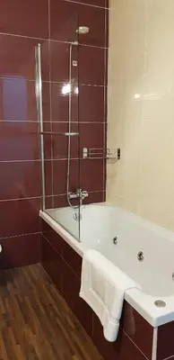 a bathroom with a tub and a glass shower at LA CASA DE HERACLES CADIZ in Cádiz